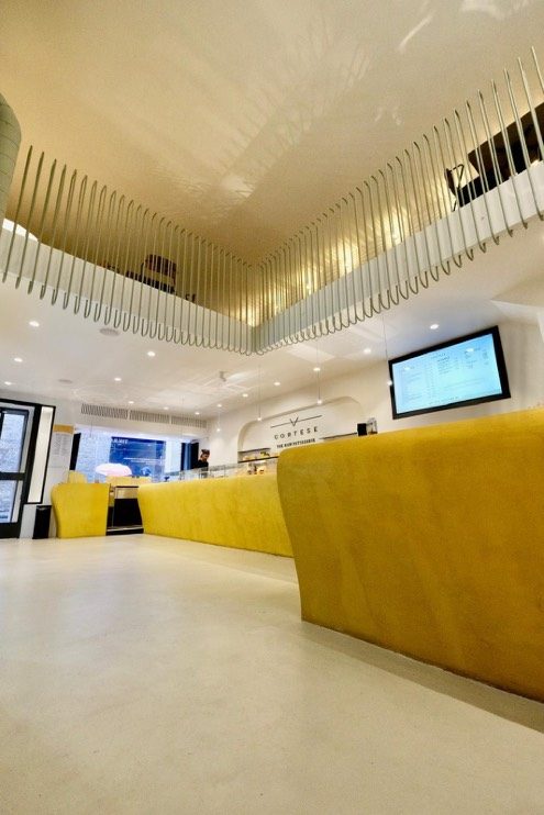 Cortese Café — bancone giallo e dettaglio soppalco