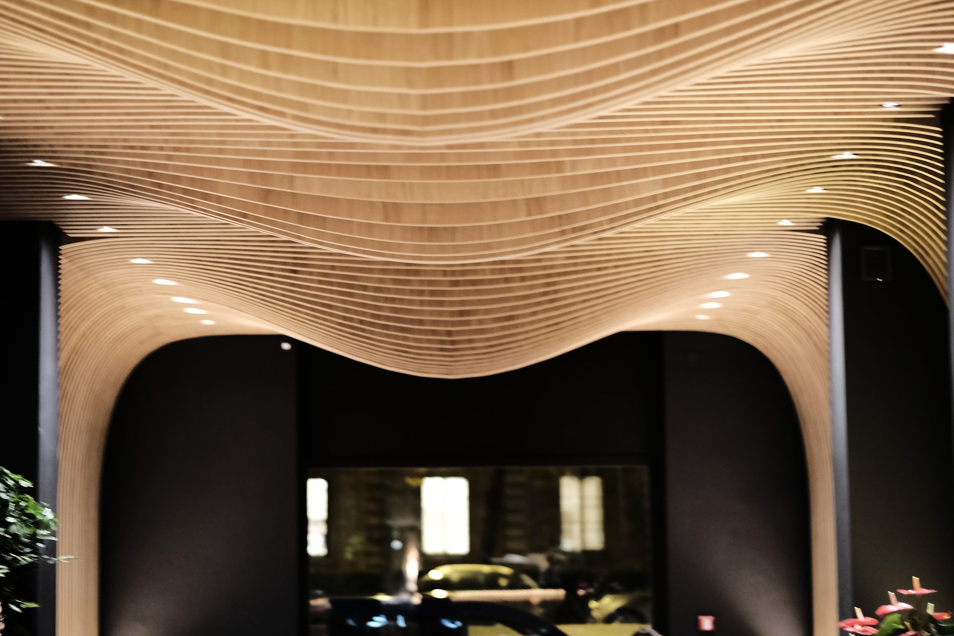 Aji Tei — vista simmetrica frontale degli archi di onde di legno con finestra in fondo